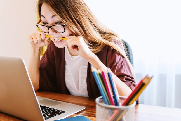 Frau am lernen mit Bleistift im mund